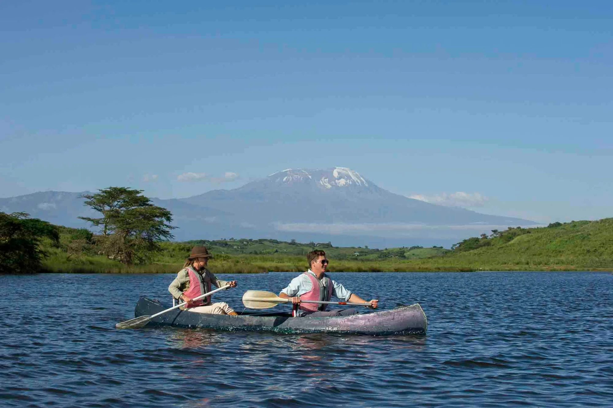 Canoë sur les calmes lacs Momella avec des oiseaux aquatiques et le sommet du Mount Meru se reflétant dans l'eau