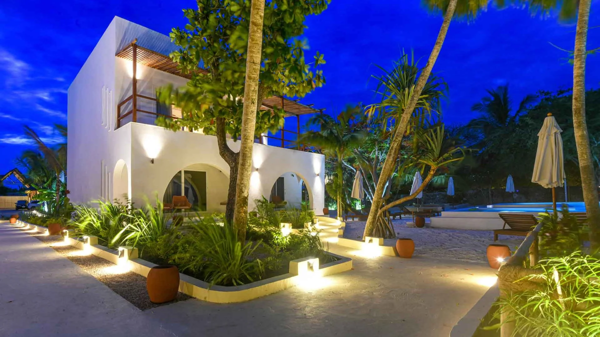 Chambre d'hôtel-boutique avec mobilier africain artisanal et terrasse sur jardin