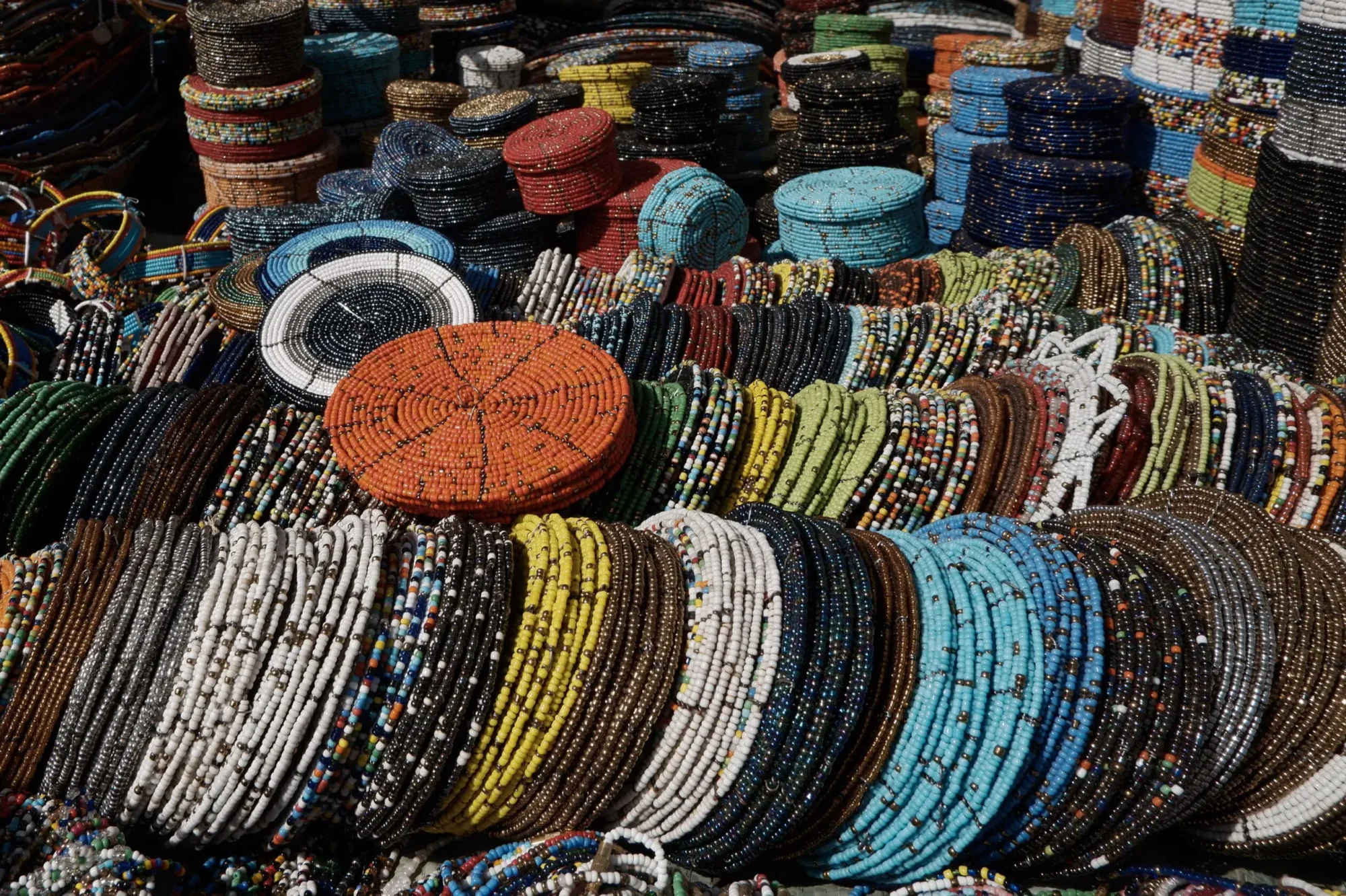 Coloratissimi gioielli in perline Maasai e kanga esposti su una bancarella del mercato vicino alla Clock Tower di Arusha