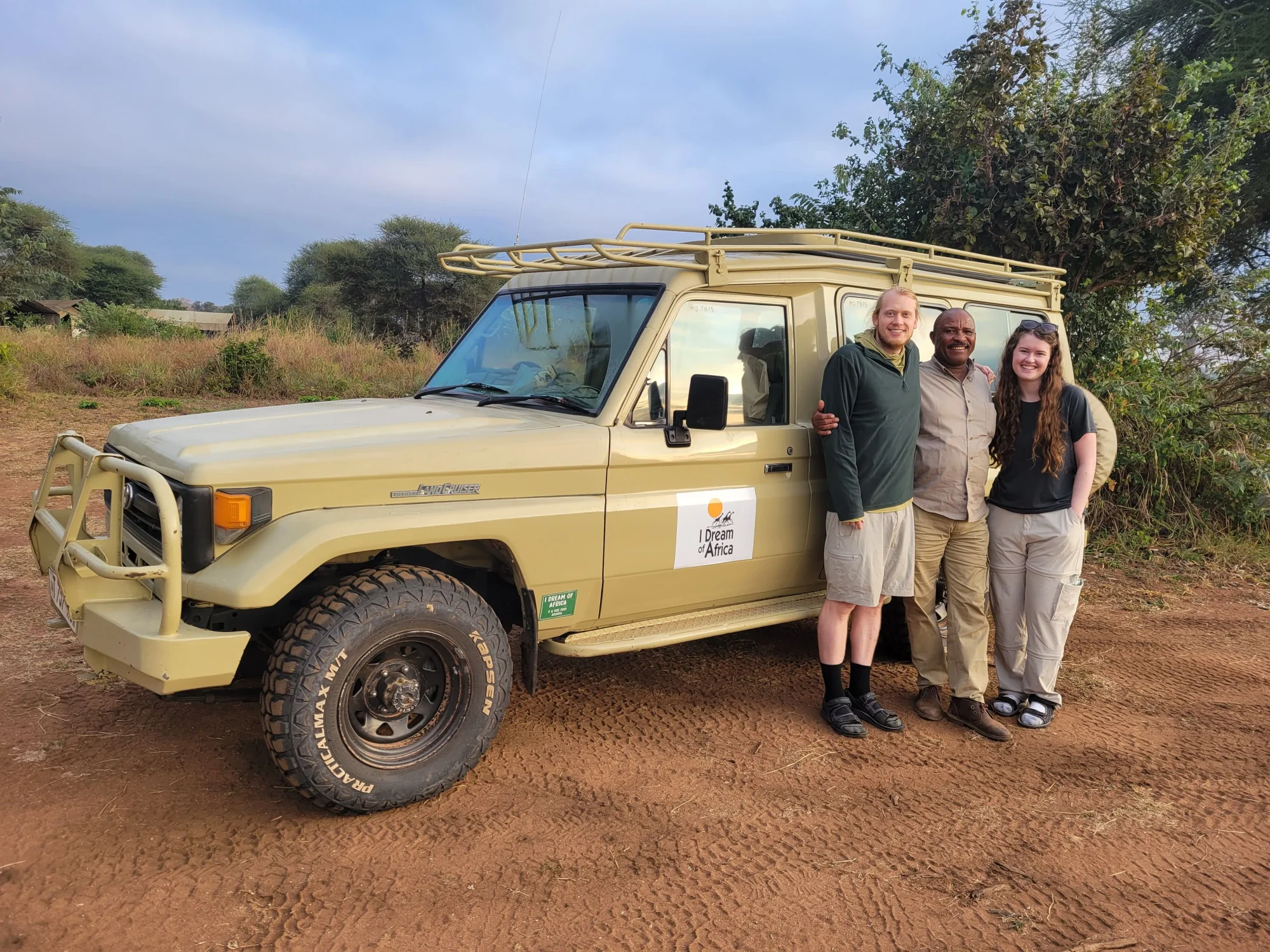 Guide de safari examinant une carte d'itinéraire avec des clients pendant le petit-déjeuner dans un lodge d'Arusha