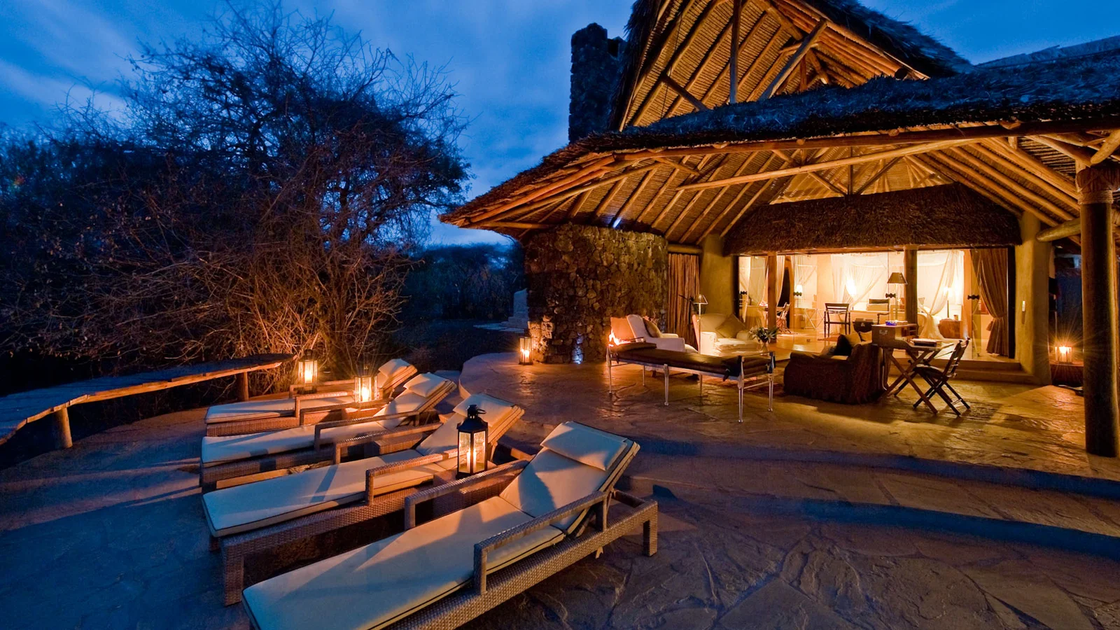 Ein Dach-Sternenbett in der ol Donyo Lodge, für die Nacht hergerichtet mit Himmelbett-Moskitonetz, Gaslampen und dem ungestörten Chyulu-Himmel