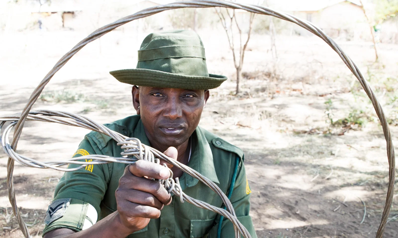 Ein Massai-Moran-Guide führt eine kleine Gruppe auf einer Wandersafari durch Akazienwald auf der Kuku Group Ranch