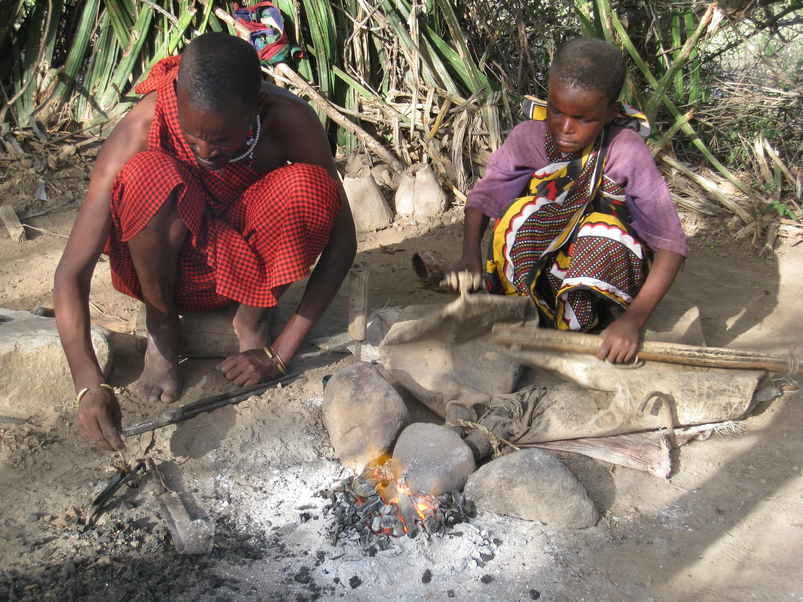 Forgeron datoga travaillant à une forge au charbon de bois, produisant des bijoux traditionnels