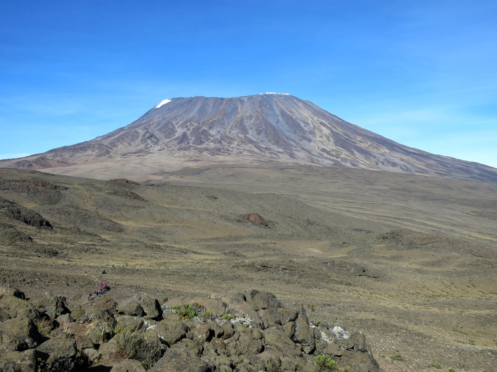 Ciel bleu dégagé au-dessus du sommet de Kibo, sur le Kilimanjaro, avec des sentiers secs et un désert alpin brun pendant la saison sèche