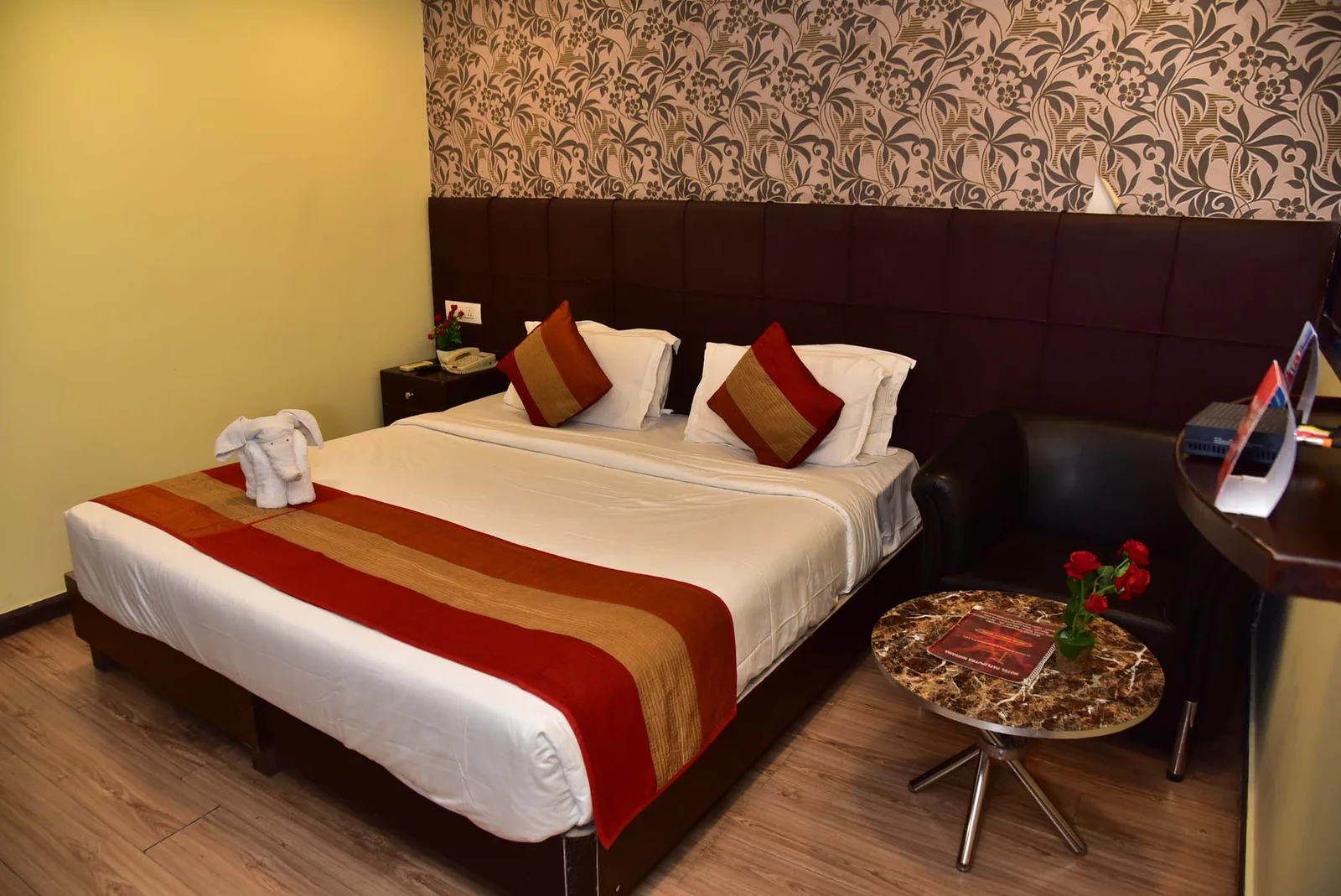 Chambre d'hôtel économique simple mais propre à Moshi, avec ventilateur de plafond et vue sur le Kilimanjaro depuis la fenêtre