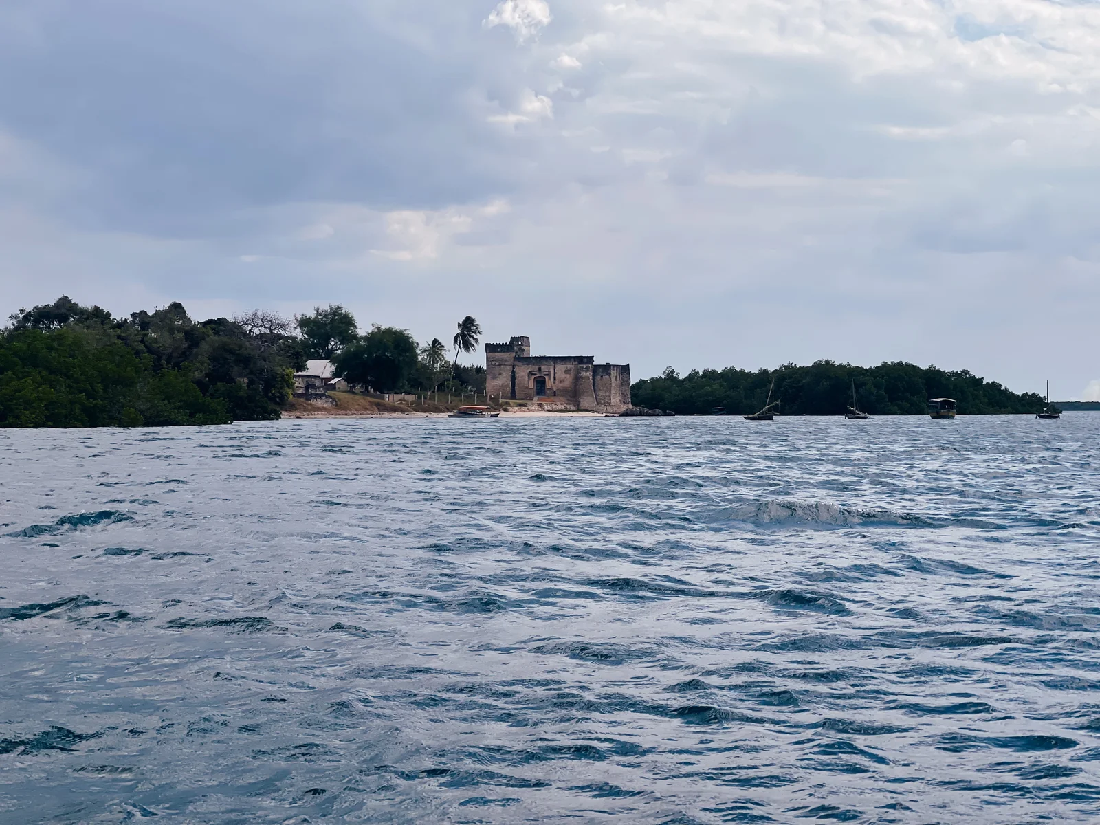 Acque calme dell'Oceano Indiano al largo di Kilwa Kisiwani durante la stagione secca con cieli azzurri e tersi