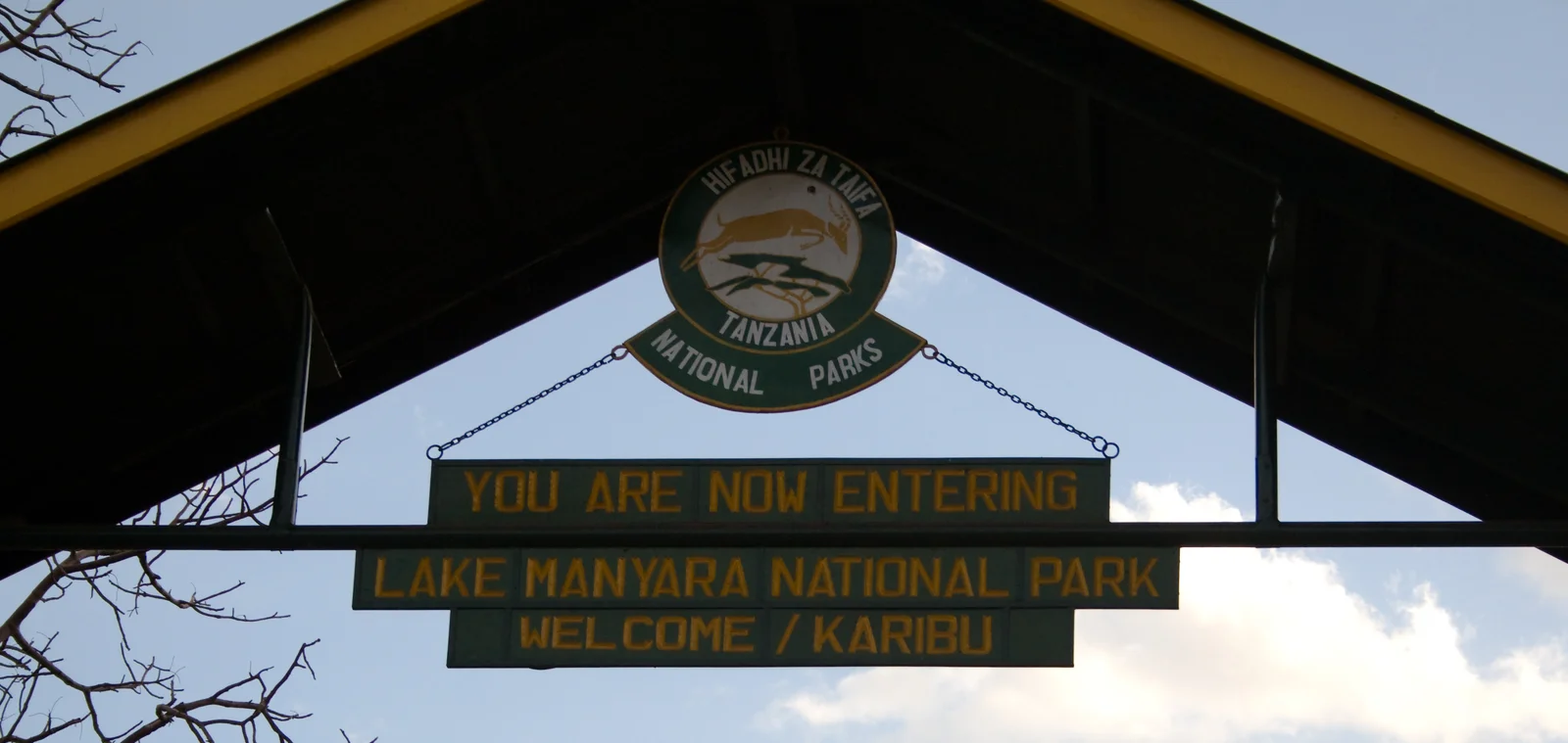 Haupttor des Lake Manyara National Park bei Mto wa Mbu, im Hintergrund die aufragende Steilwand des Rift Valley
