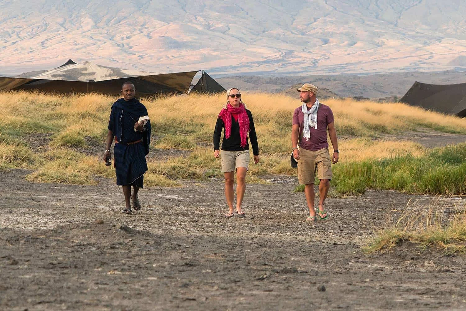 Guide Maasai menant des visiteurs à travers les étendues de soude vers des groupes de flamants en train de s'alimenter au lac Natron
