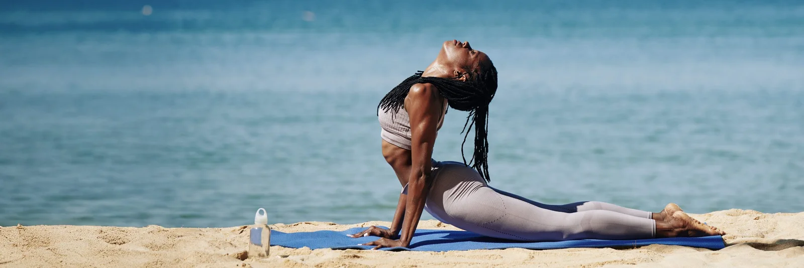 Yogastunde auf den Dünen von Shela mit dem Indischen Ozean im Hintergrund