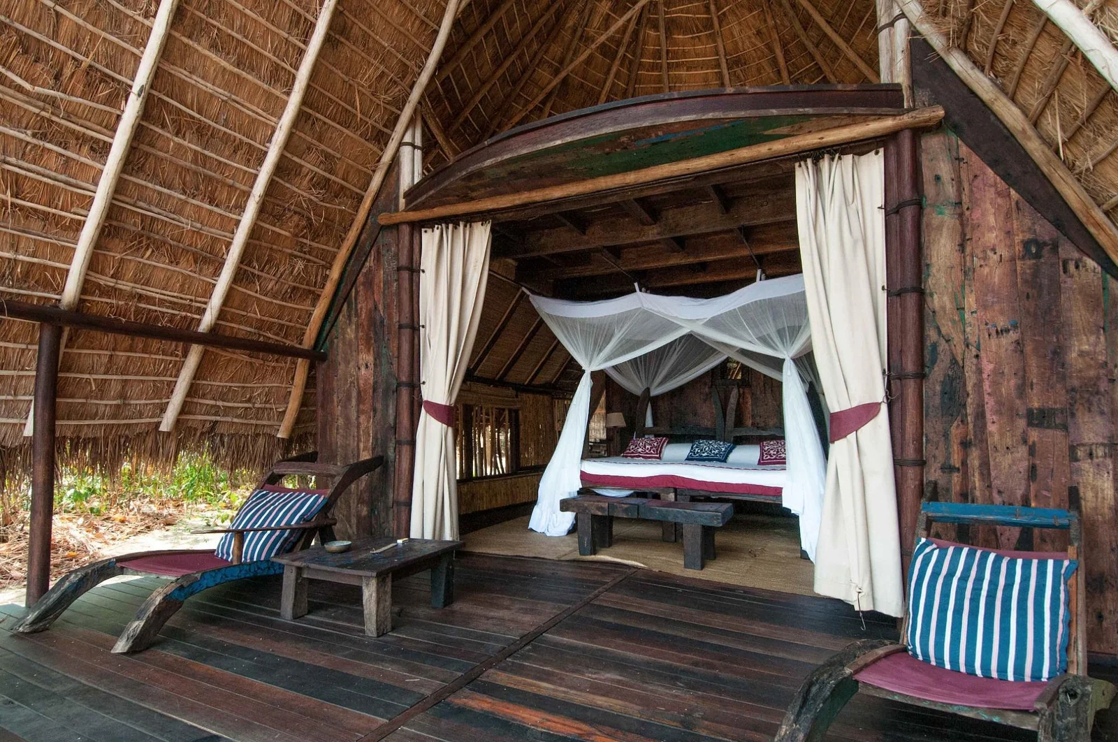 Intérieur d'une banda de Greystoke Mahale, avec un lit à moustiquaire face au lac