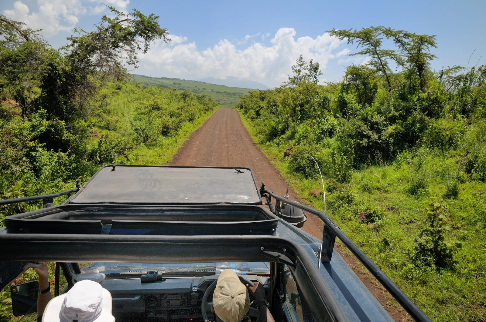 Vehículos de safari descendiendo por la Seneto Road hacia el cráter del Ngorongoro con la luz de la mañana temprano