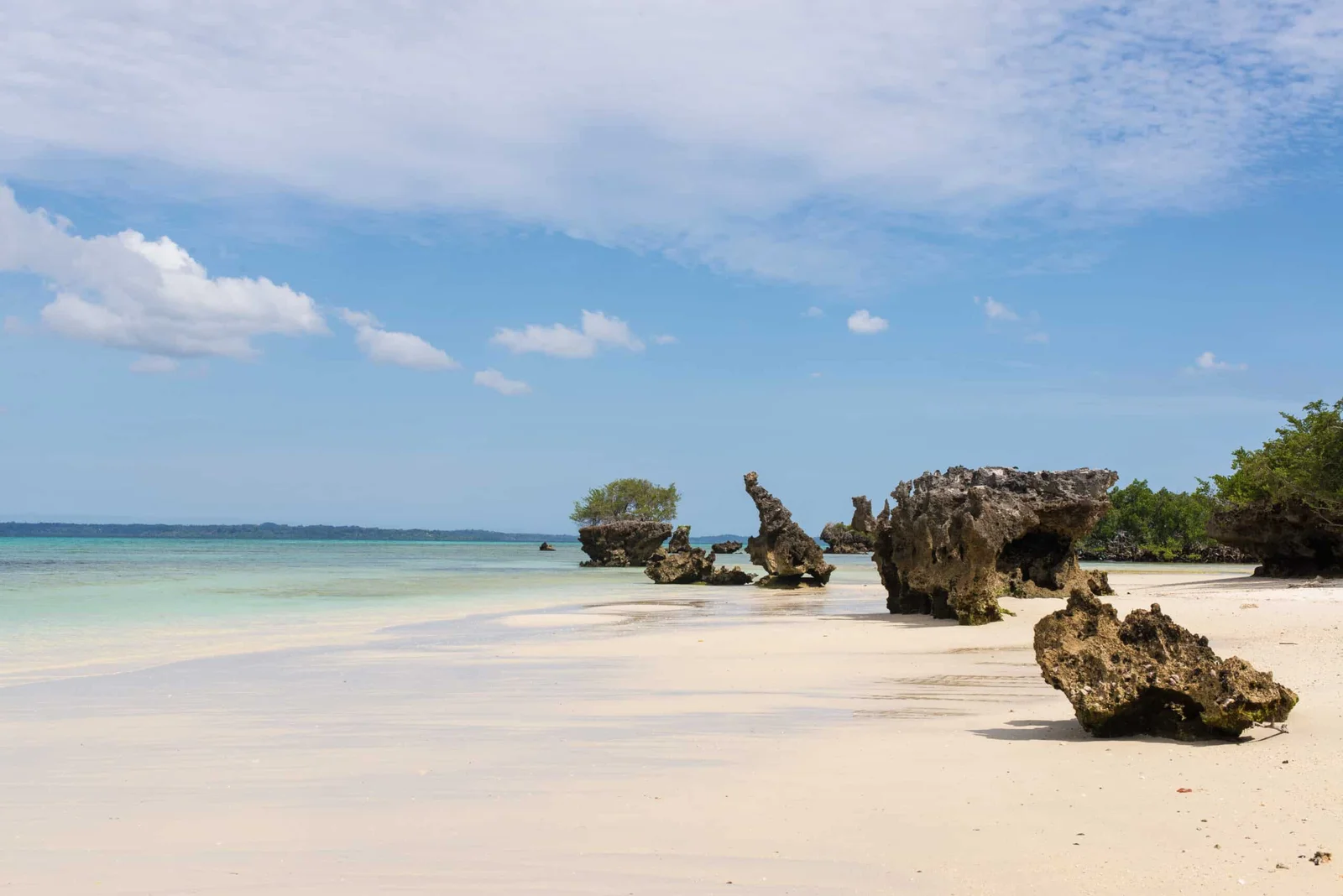 Front de mer d'une pension économique de Pemba, avec un boutre traditionnel posé sur le sable