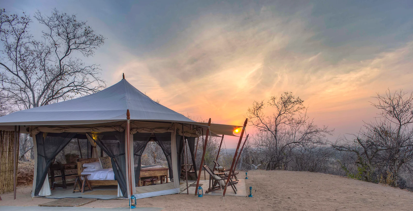 Une tente de safari classique en toile installée le long d'une rivière de sable asséchée à Ruaha
