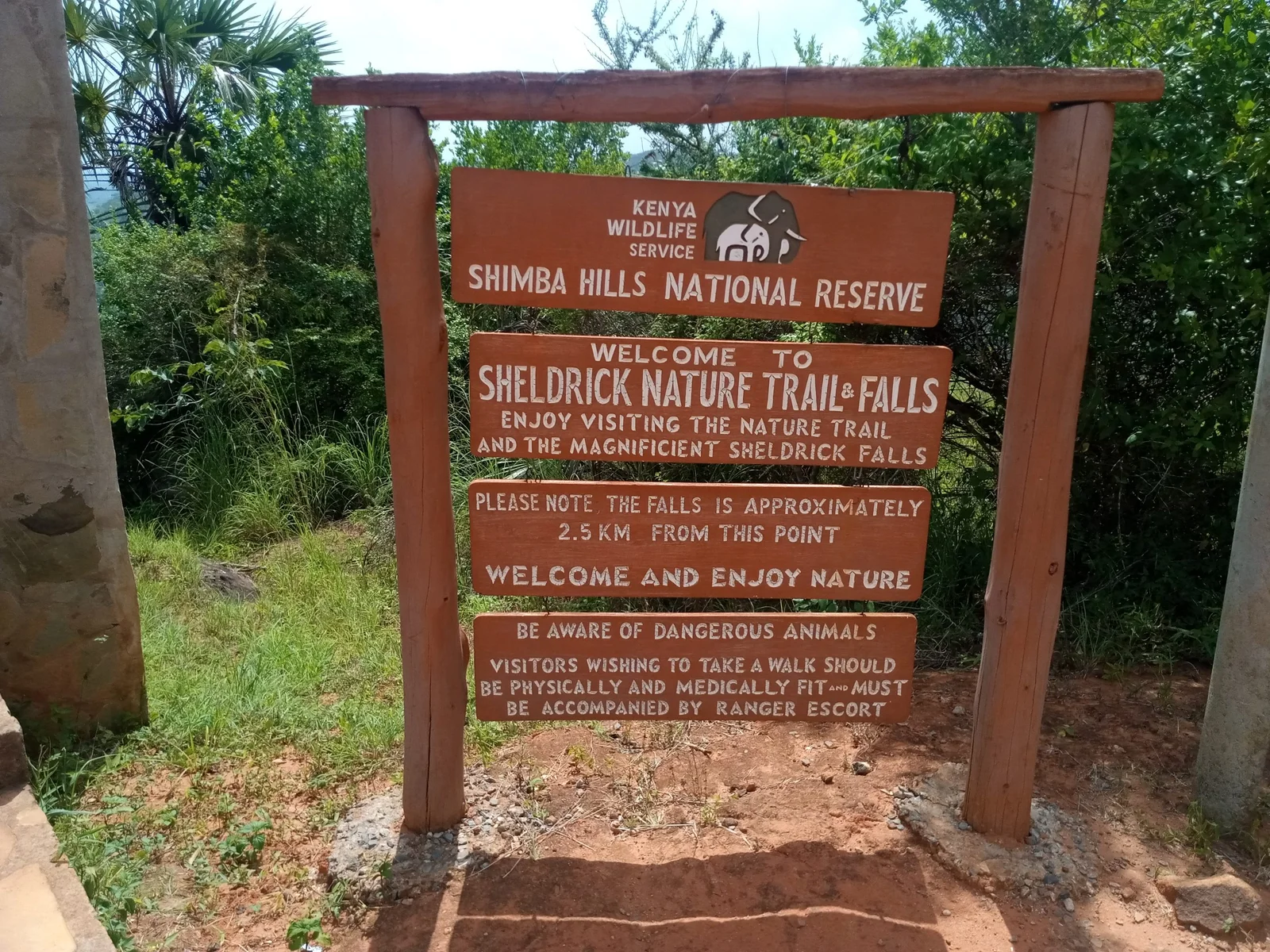Le panneau du poste de ranger des Sheldrick Falls, au départ du sentier, avec un ranger armé du KWS prêt à guider un groupe