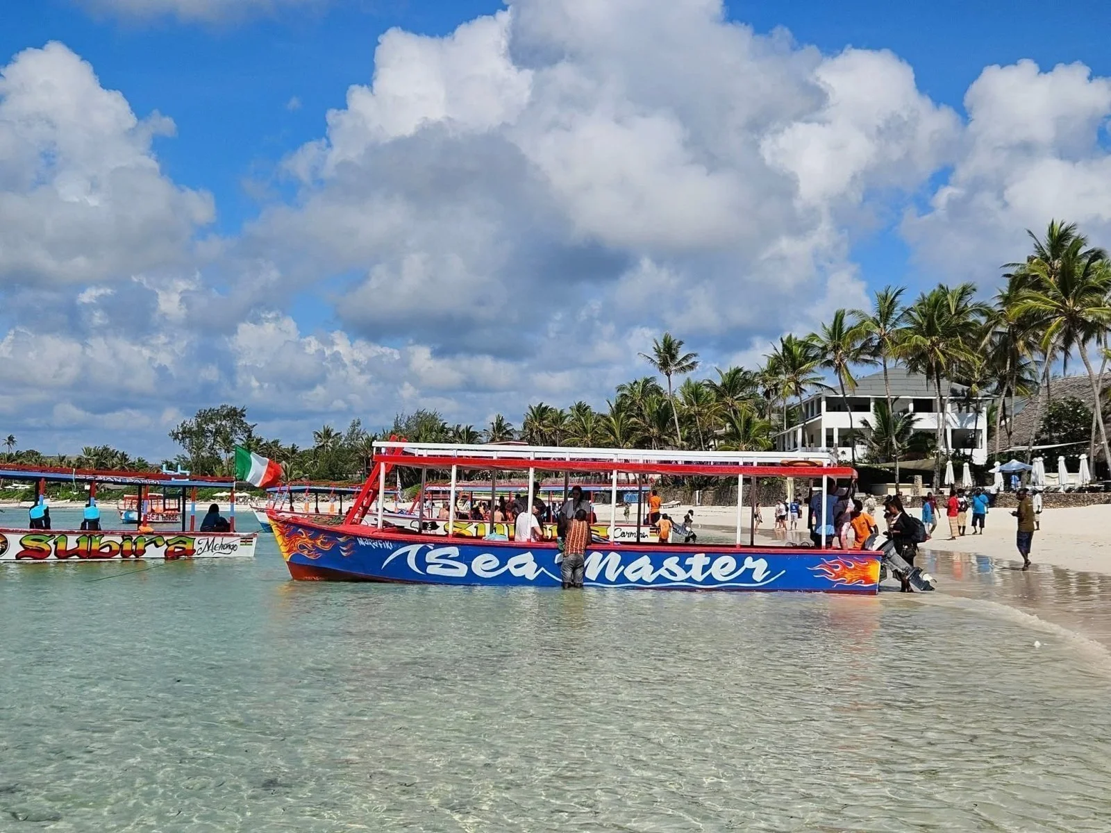 Ein Glasbodenboot im Watamu Marine National Park mit Schnorchlern im Wasser über dem Fleckenriff