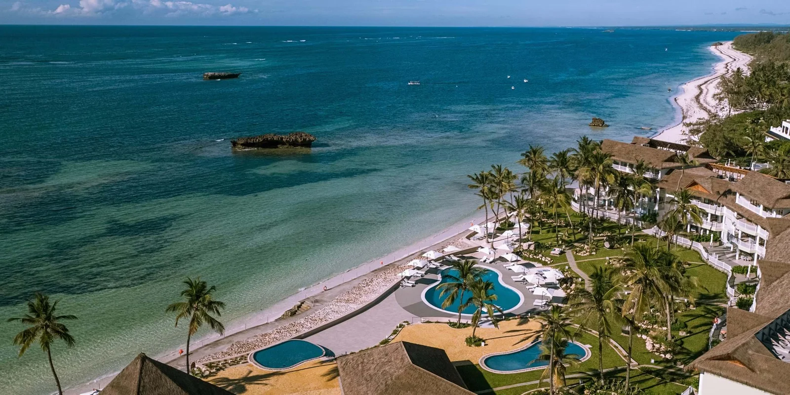 Eine einzelne Watamu-Bucht innerhalb des Meeresparks bei Flut, die die Boutique-Strandfront und das nur wenige Meter vor der Küste liegende Schutzriff zeigt