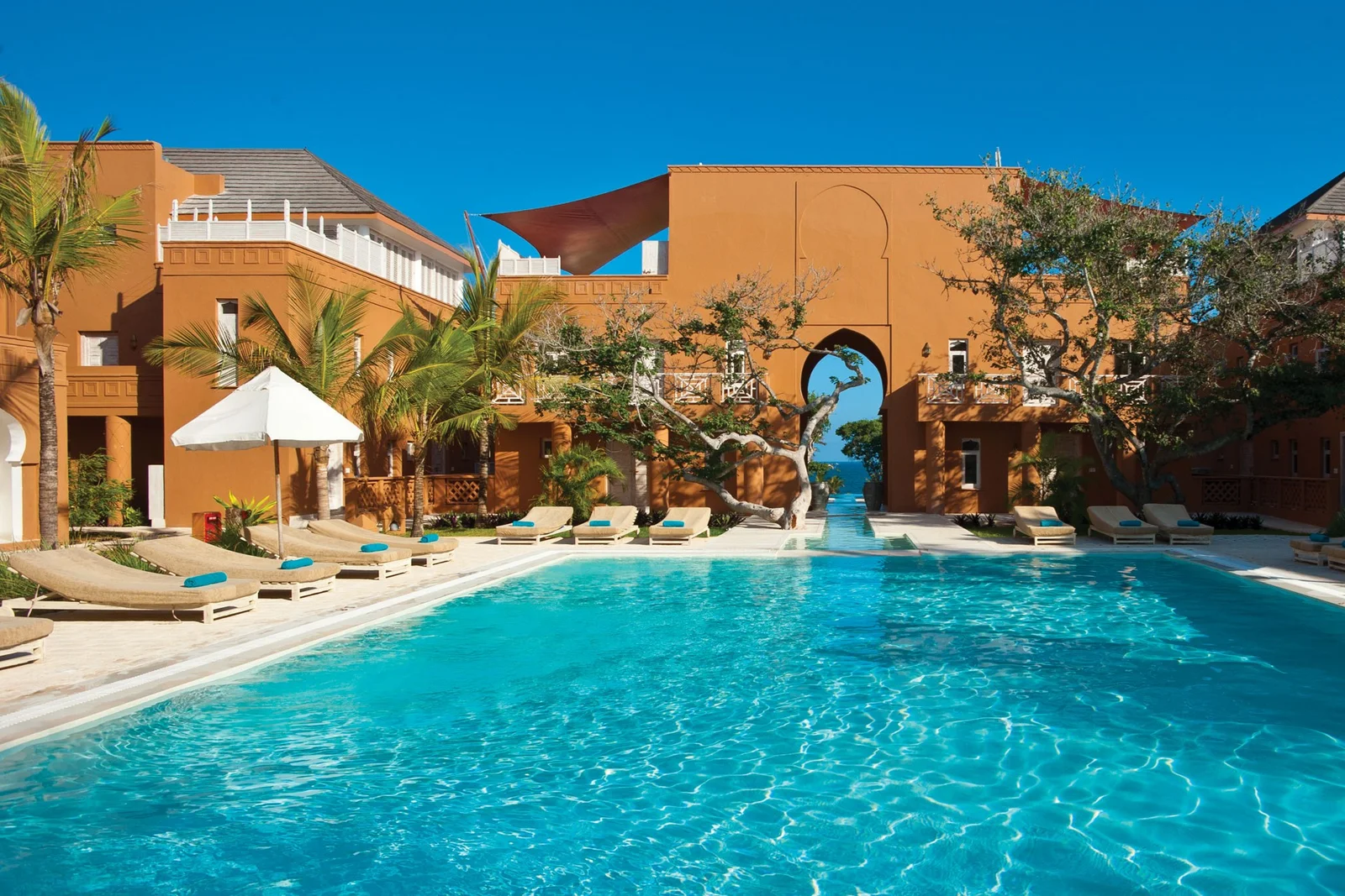 Der marokkanisch-suahelische Innenhof von Medina Palms mit weiß getünchten Bögen und einem Brunnen