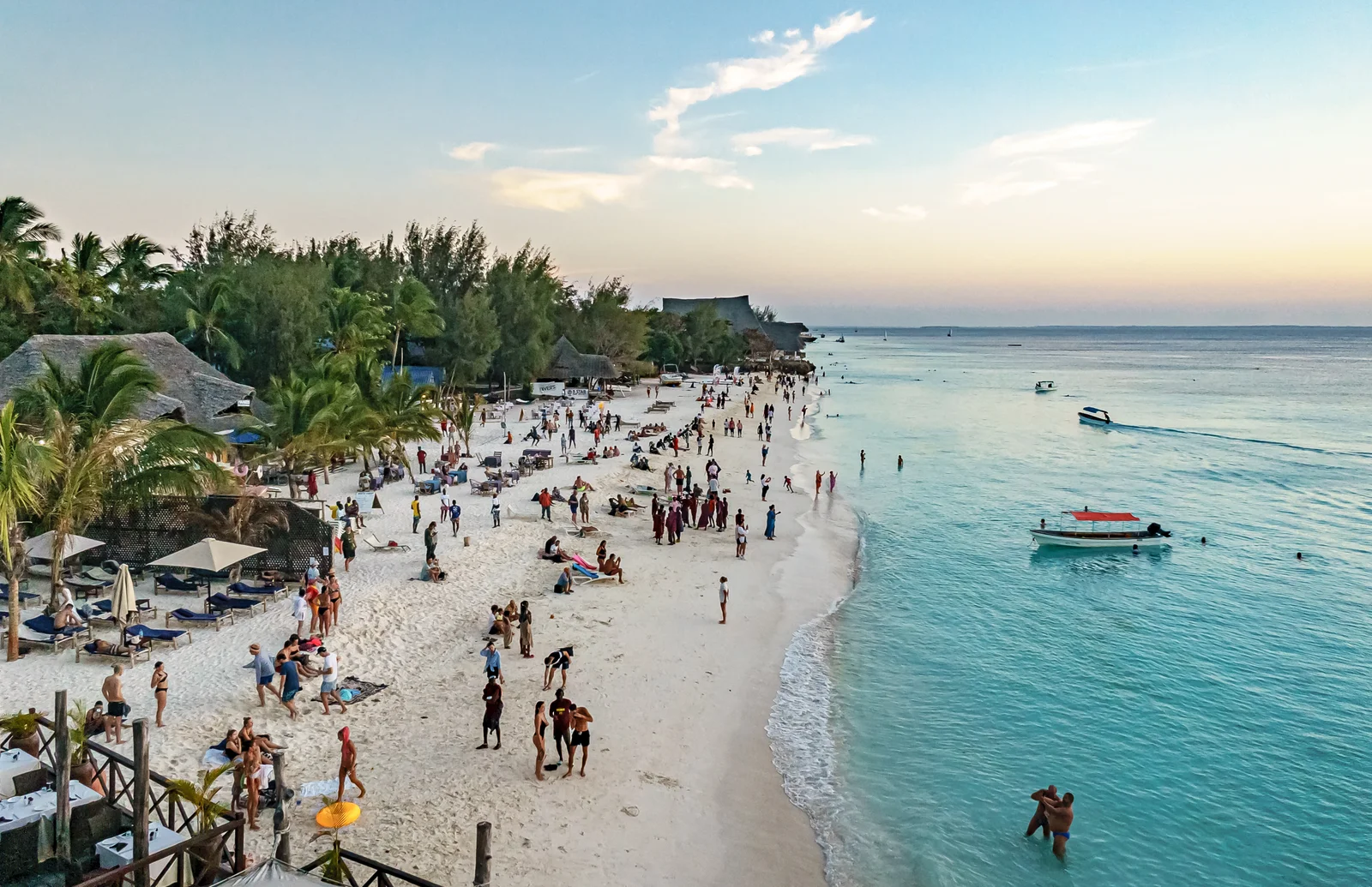 La playa en media luna de Nungwi con palmeras y bañistas en marea alta