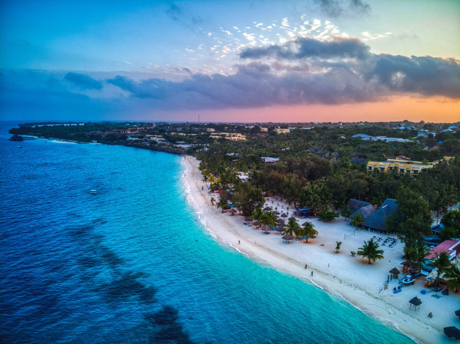 Nubes dramáticas tras la lluvia y palmeras exuberantes enmarcando una playa de la costa este de Zanzibar en noviembre