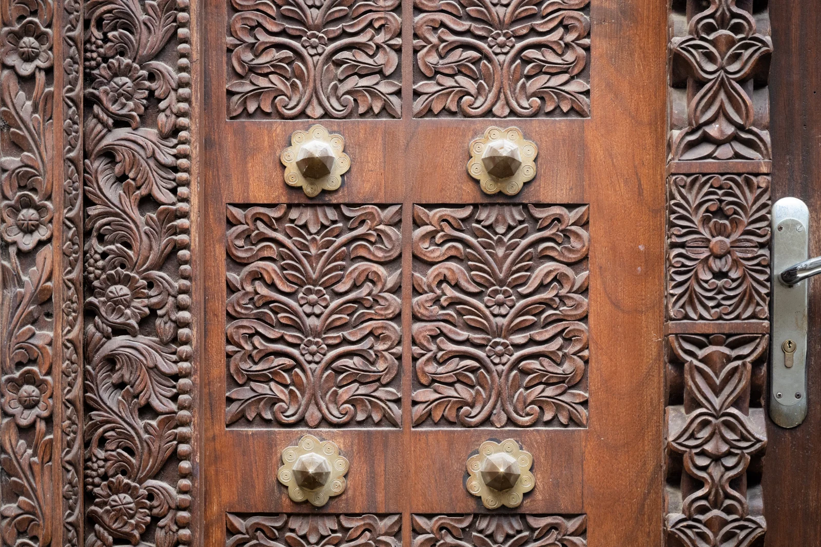 Puerta de madera zanzibarí intrincadamente tallada con tachuelas de latón en el barrio de Shangani, en Stone Town